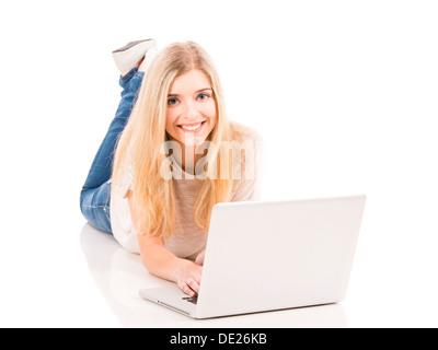 Beautiful and happy woman lying on the floor and working with a laptop, isolated over white background Stock Photo