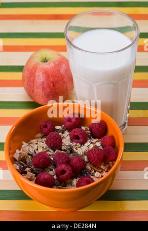 Fruit muesli with raspberries, an apple and a glass of milk Stock Photo