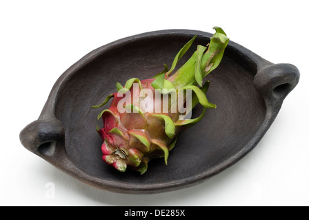 Red Pitaya (Hylocereus undatus) in an archaic clay bowl Stock Photo