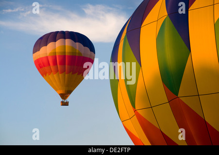 Multi-colored hot-air balloon with another in foreground Stock Photo