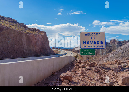 Welcome to Nevada on the Arizona and Nevada state line by the Hoover Dam. A Pacific Time Zone sign is below it. Stock Photo