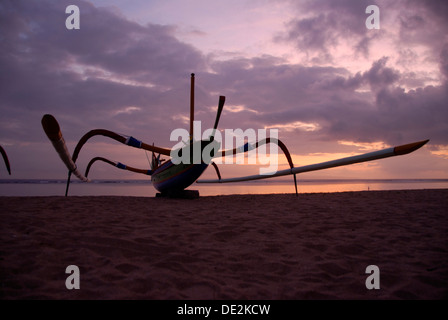 Sunrise, fishing boat with outrigger in silhouette, beach of Sanur, Bali, Indonesia, Southeast Asia, Asia Stock Photo