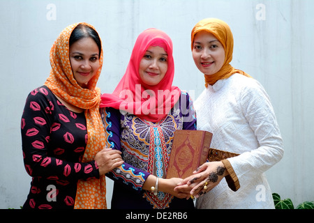 women in full muslim dress holding a copy of the al koran Stock Photo