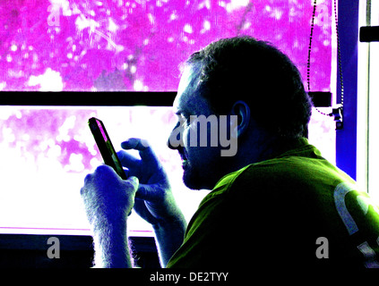 digitized portrait of adult male texting on mobile phone in front of window Stock Photo