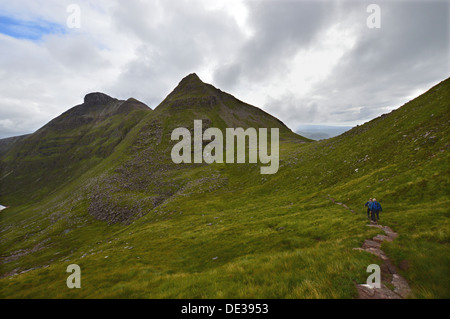 Two hill walkers on footpath heading towards the Scottish mountain Spidean Coinich (a Corbett) on Quinag. Stock Photo