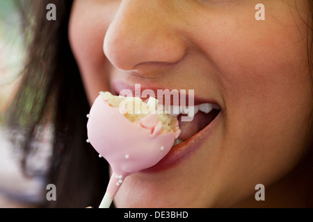 Woman eating a cake pop Stock Photo