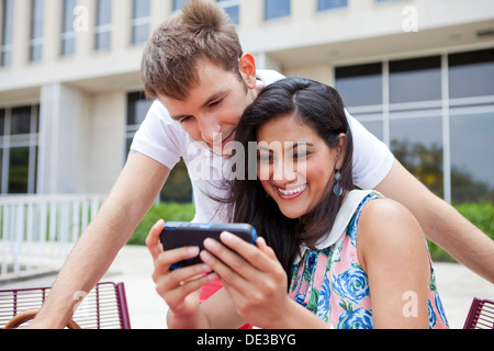 Happy young couple looking at smart phone Stock Photo