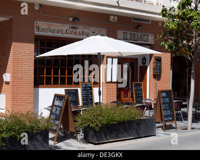 Cafe/bar with menus and seating areas outside. The menus are written on a blackboard in chalk Stock Photo