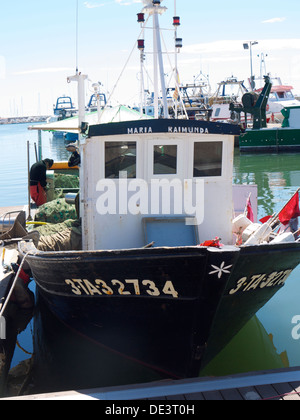 Fisherman tending to his nets on board his fishing boat Stock Photo