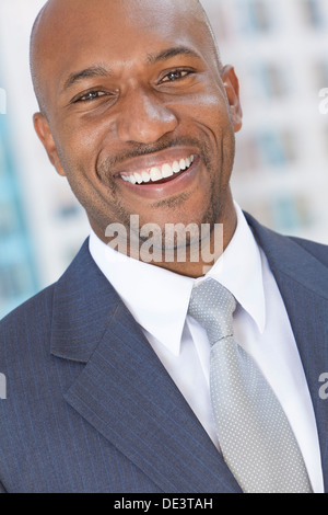 Successful and happy smiling African American businessman or man arms in a modern city Stock Photo
