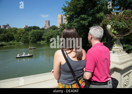 Tourists Looking at The Lake from Bow Bridge in Central Park, NYC Stock Photo