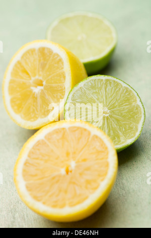 Delicious, fresh, juicy and appetizing lemons and limes cut in half and laid out on a wooden surface Stock Photo