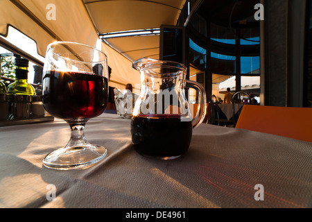 carafe and glass of red wine on the table of an Italian restaurant Stock Photo