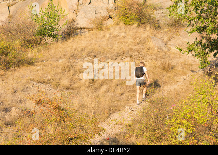 Rear view of a solitary man hiking on a mountain path in a hot day of summer Stock Photo