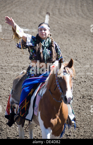 Indian Tribeswoman in traditional dress riding horseback saluting, Ellensburg Rodeo opening ceremony, 2012 WA USA Stock Photo