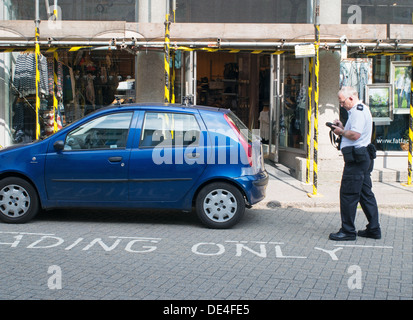 Traffic warden booking parked car Tavistock, Devon, England, UK Stock Photo