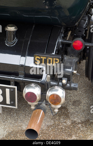 The rear 'Stop' brake light on a vintage car, along with other rear lights. Stock Photo