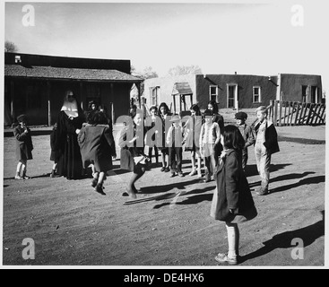 In Taos County, New Mexico, a Catholic Sister assists with a classroom activity at Costilla School, showcasing the role of religious figures in education during the early 20th century. Stock Photo