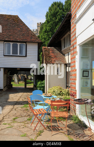 Chairs and tables outside West End House art gallery cafe at entrance to church of St Michael in Smarden Kent England UK Stock Photo