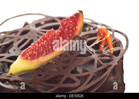 Miniature figure of a construction worker on a chocolate cupcake Stock Photo