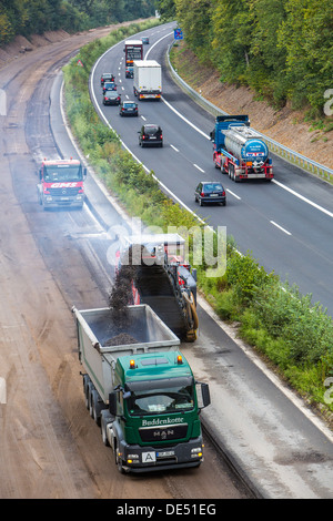 Roadworks, on Autobahn A52, Essen, Germany.  Removal of the asphalt surface with a cutter, then new, porous asphalt is applied.