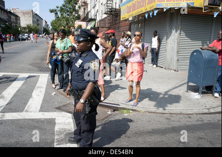 2012 West Indian/Caribbean Kiddies parade, Crown Heights. Female, African-American police officer maintains order. Stock Photo