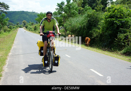 Traveller ride bicycle on the road conect Dalat to Daklak, this is the nice road with fresh air, neglected landcape. Viet Nam- S Stock Photo