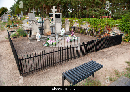 family graves with fence and bench on cemetery near woods in Odrzywół, Poland, Europe Stock Photo