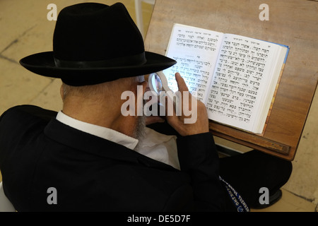 An Ultra Orthodox Jew reading the Sidur prayer book in the Synagogue of the Western Wall in East Jerusalem Israel Stock Photo
