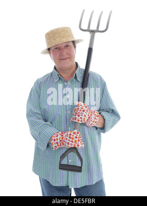 Senior woman gardener wearing straw hat and rubber boots posing with forks over white background Stock Photo
