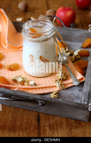 homemade yogurt and a jar with dried apricots and nuts, food close up Stock Photo