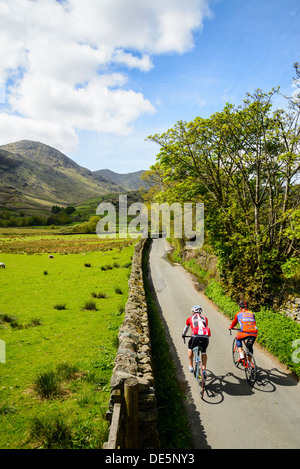 Cyclists in Little Langdale in the English Lake District with the Coniston Fells behind Stock Photo