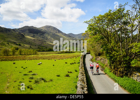 Cyclists in Little Langdale in the English Lake District with the Coniston Fells behind Stock Photo