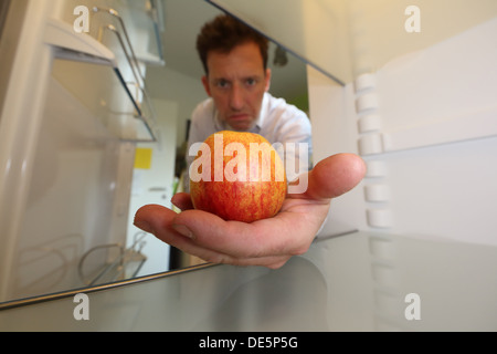 Berlin, Germany, Claus brings an apple from his empty fridge Stock Photo