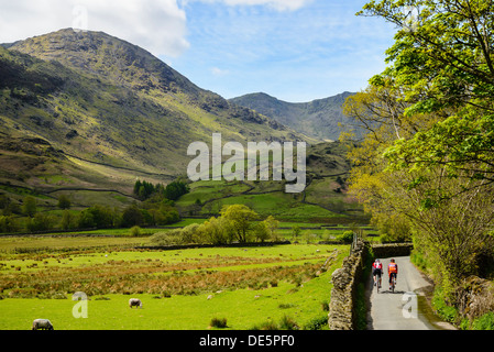 Cyclists in Little Langdale in the English Lake District with the Coniston Fells behind Stock Photo