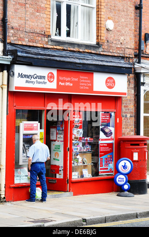 A red UK Post Office ATM providing services by the Bank of Ireland hole ...