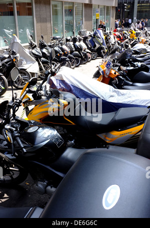 Commuters motor bikes and mopeds parked tightly in the City of London as workers avoid the congestion charge Stock Photo