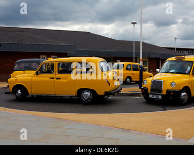 Yellow taxis parked on a taxi rank outside Derby railway station Derbyshire England UK Stock Photo