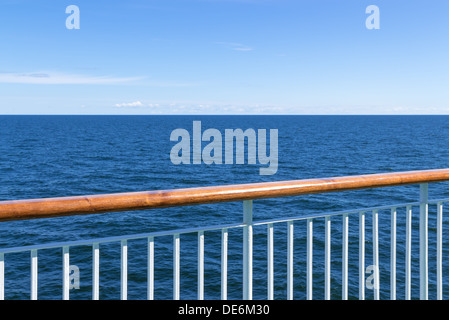 Passenger ship railing with sea and blue sky in the background. Stock Photo