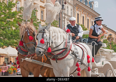Horse-drawn carriages for hire in Krakow's Main Market Square. Stock Photo
