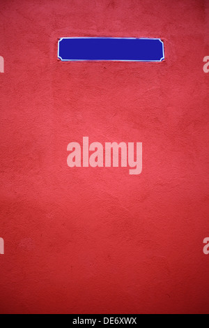 Color shot of an empty blue street sign on a red wall Stock Photo