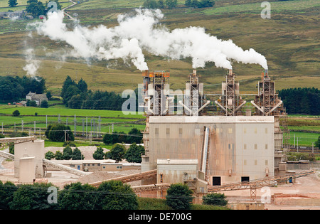 Four industrial chimneys belching smoke into the atmosphere Stock Photo