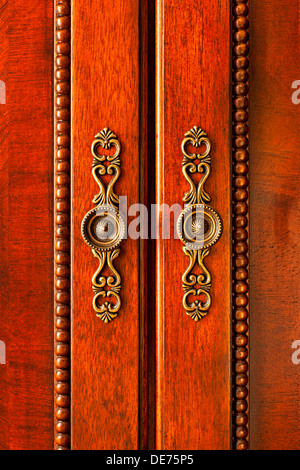 Ornate handles on wooden cabinet doors closeup Stock Photo