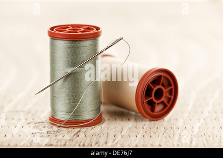Two spools of thread with needle for sewing Stock Photo