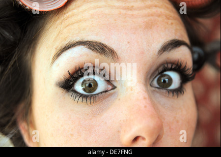 Young beautiful woman 20s with rollers in her hair and wearing eyelash extensions getting ready for a night out Stock Photo