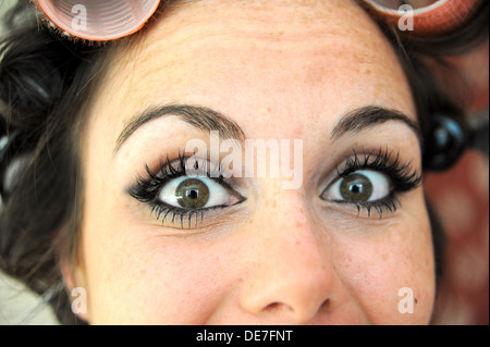 Young beautiful woman 20s with rollers in her hair and wearing eyelash extensions getting ready for a night out Stock Photo