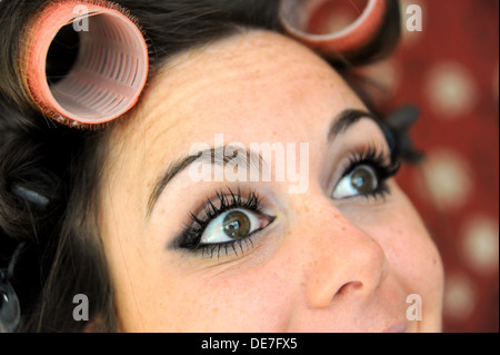 Young beautiful woman 20s with rollers in her hair and wearing eyelash extensions getting ready for a night out Stock Photo
