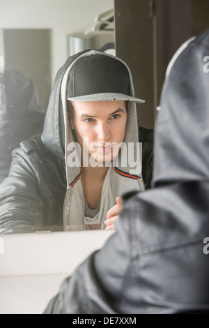 Confident young man with cool attitude sitting in front of mirror Stock Photo