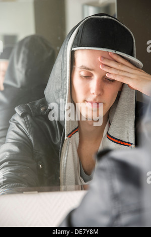 Worrying and stressed young man with cool attitude sitting in front of mirror Stock Photo