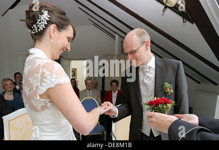 Buckow, Germany, groom puts his bride at the civil ceremony the ring on Stock Photo